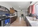 Modern kitchen featuring stainless steel appliances, dark cabinetry, and a view to the outdoor patio at 5168 Wilbur St, Las Vegas, NV 89119