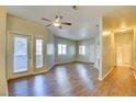 Spacious living room featuring hardwood floors, a ceiling fan, and natural light from multiple windows at 5250 S Rainbow Blvd # 2120, Las Vegas, NV 89118
