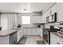 Modern kitchen featuring stainless steel appliances, white cabinets, and tile backsplash, ready for culinary adventures at 7017 Pink Flamingos Pl, North Las Vegas, NV 89084