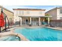 A backyard oasis featuring a refreshing pool, relaxing hot tub, and covered patio perfect for entertaining at 7017 Pink Flamingos Pl, North Las Vegas, NV 89084