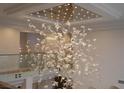 Modern crystal chandelier hanging over the landing of the glass-enclosed staircase at 74 Innisbrook Ave, Las Vegas, NV 89113