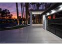 Spacious driveway leading to a modern garage with glass panel doors, complemented by manicured landscaping and elegant lighting at 74 Innisbrook Ave, Las Vegas, NV 89113
