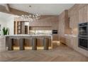 Gourmet kitchen with wood cabinets, eat-in island, herringbone floor and modern stainless steel appliances at 74 Innisbrook Ave, Las Vegas, NV 89113