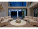 Bright living room with modern sofas, herringbone floors, and large windows providing scenic outdoor views at 74 Innisbrook Ave, Las Vegas, NV 89113
