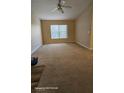 Bright living room with neutral carpeting, ceiling fan, and large window at 8000 W Badura Ave # 2021, Las Vegas, NV 89113