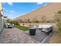 Back yard features patio seating with manicured plants and a faux grass area at 8705 Fordster St, Las Vegas, NV 89166