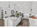 Bright kitchen features white cabinets, a large island, stainless appliances, and pendant lighting at 8705 Fordster St, Las Vegas, NV 89166