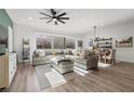 Sun-filled living room with hardwood flooring, a sectional sofa, and a decorative ceiling fan at 8705 Fordster St, Las Vegas, NV 89166
