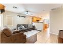 Cozy living room featuring tile flooring, a ceiling fan, and neutral paint that connects to the kitchen at 9527 Havasu Canyon Ave, Las Vegas, NV 89166