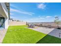 An amazing backyard with artificial grass, a patio area, and lovely landscaping at 116 Juliette Pointe Ln, Henderson, NV 89011