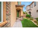 This home has a stone accent, desert landscaping, and a welcoming green front door at 12240 Old Muirfield St, Las Vegas, NV 89141