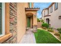 Inviting front entrance with a green door, stone accents, and a well-maintained walkway leading to the home at 12240 Old Muirfield St, Las Vegas, NV 89141