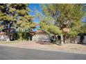 Charming single-story home with a brick driveway and lush landscaping, mature trees at 1905 Calle De Espana, Las Vegas, NV 89102