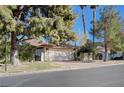 Charming single-story home with a brick driveway, lush landscaping, and mature trees at 1905 Calle De Espana, Las Vegas, NV 89102