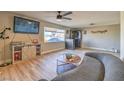 Spacious living room with light wood floors, ceiling fan, and a large window at 2129 N Michael Way, Las Vegas, NV 89108