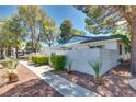 Single-story home featuring desert landscaping, blue-tiled roof, and a sidewalk entrance at 2141 Twickenham Pl # A, Las Vegas, NV 89108