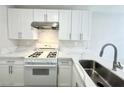 Modern kitchen featuring white cabinets, stainless steel appliances, and bright quartz countertops at 2525 Sierra Bello Ave # 103, Las Vegas, NV 89106