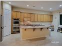 Spacious kitchen featuring a central island, double ovens and wood cabinetry at 2764 Leys Burnett Ave, Henderson, NV 89044