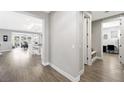 Hallway with gray walls, white trim, and luxury vinyl plank flooring leads to office and living areas at 32 Via Del Fiume, Henderson, NV 89011