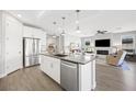 Bright, modern kitchen with white cabinets, stainless steel appliances, and a large island opening to living area at 32 Via Del Fiume, Henderson, NV 89011