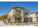 Side view of a beige two-story home featuring desert landscaping and a brick-paved driveway leading to the garage at 4813 Stony Hill St, North Las Vegas, NV 89031