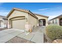 Inviting single-story home with an attached two-car garage, desert landscaping, and a cozy front porch at 6144 Corbin Ave, Las Vegas, NV 89122