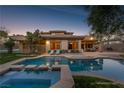 Relaxing pool view with step stones, spa, lush green grass, lounge chairs, and outdoor kitchen at 68 Isleworth Dr, Henderson, NV 89052