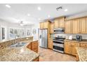 Well-lit kitchen features stainless steel appliances, granite counters, and breakfast bar at 9435 Westwind Rd, Las Vegas, NV 89139