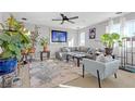 Bright living room with a comfortable gray sectional, stylish decor, and lush indoor plants at 10415 Scarpa St, Las Vegas, NV 89178