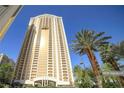 Exterior of high-rise building with clear blue sky backdrop and palm trees at 125 E Harmon Ave # 809, Las Vegas, NV 89109