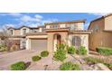 Picturesque exterior showcasing a brick driveway, desert landscaping, and an arched entryway at 12816 Alcores St, Las Vegas, NV 89141