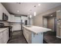 Modern kitchen features stainless appliances, a large island, and white cabinetry for a clean, contemporary look at 12816 Alcores St, Las Vegas, NV 89141