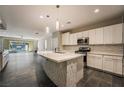 Bright kitchen with stainless steel appliances and a large island with mosaic tile accents at 12816 Alcores St, Las Vegas, NV 89141