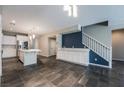 Open-concept living space with kitchen island, built-in cabinets, and stairs leading to the second floor at 12816 Alcores St, Las Vegas, NV 89141