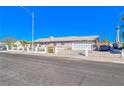 Single-story home with front yard featuring xeriscaping, a double-door garage, and large driveway at 1805 Ivanhoe Way, Las Vegas, NV 89102