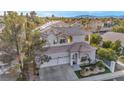 Charming two-story home featuring a three-car garage, arched windows, and a well-manicured front yard at 2107 Eaglepath Cir, Henderson, NV 89074