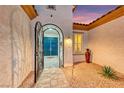 Elegant courtyard entry with iron gate and arched doorway leading to the striking blue front doors at 2239 Discovery Lake Ct, Henderson, NV 89044