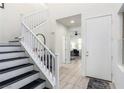 Bright foyer with staircase, tiled floors, and a view into a home office with a ceiling fan at 306 Dedication Ave, Henderson, NV 89011