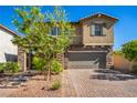 Beautiful two-story home featuring stone accents, a well-manicured lawn, and a brick driveway at 306 Dedication Ave, Henderson, NV 89011