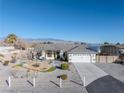 Wide exterior shot showing the home and surrounding area with xeriscape, mountain views, and vehicle cover at 341 Dylan Pl, Pahrump, NV 89048