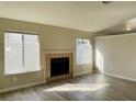 Inviting living room featuring a fireplace, light wood floors, and multiple windows for ample natural light at 4240 Caliper Dr, Las Vegas, NV 89110