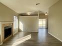 Inviting living room with a fireplace, light wood floors, and view into another room at 4240 Caliper Dr, Las Vegas, NV 89110