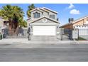 Two-story home with gray stucco, white garage door, black wrought iron gate, and palm trees at 5264 Silverheart Ave, Las Vegas, NV 89142