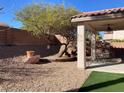 Desert landscaped backyard featuring a covered patio, gravel, rocks and rock landscaping at 5965 Poplar Tree St, Las Vegas, NV 89148