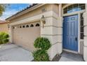 Inviting front of the house, highlighting the charming blue door, stone accents, and two-car garage, enhancing curb appeal at 5965 Poplar Tree St, Las Vegas, NV 89148