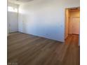 Bright living room with wood flooring, white walls, and a hallway to the bedrooms at 5965 Poplar Tree St, Las Vegas, NV 89148