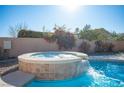 Inviting backyard pool featuring a unique stone hot tub with cascading waterfall at 7485 Rainbow Spray Dr, Las Vegas, NV 89131