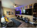 Cozy living room with modern decor, gaming setup, dark rug, and a ceiling fan at 9364 Olympia Falls Ave, Las Vegas, NV 89149