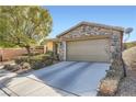 Single-story home features stone accents, a two-car garage, and a concrete driveway at 11165 Robin Park Ave, Las Vegas, NV 89138