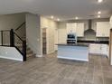 Open-concept living area showcasing modern staircase, tiled flooring, and a bright kitchen at 11394 Ethereal Landing Ave, Las Vegas, NV 89138